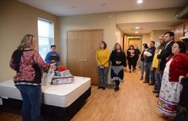 Youth and Family Therapist Sharla Burth gives a tour of one of the units at the grand opening of Mino Oski Ain Dah Yung, an affordable housing development serving homeless American Indian youth on Wednesday, Nov. 20 in St. Paul, Minn.