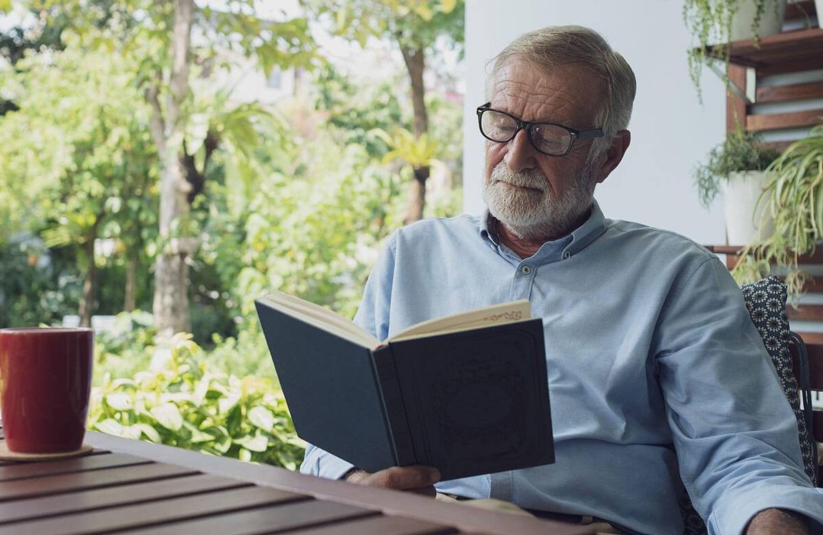 Older man reading outside