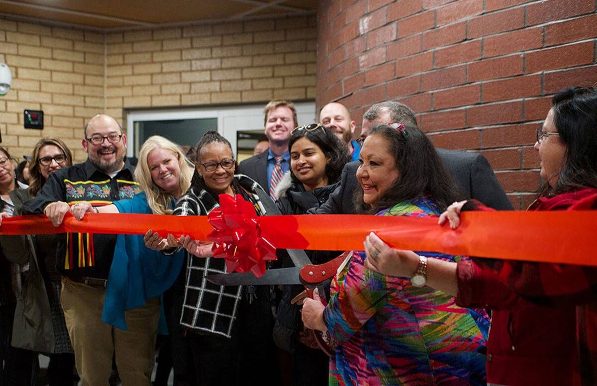 Executive Director of the Ain Dah Yung Center, Deb Foster, is joined by contributors at the ribbon cutting of Mino Oski Ain Dah Yung, an affordable housing development serving homeless American Indian youth on Wednesday, Nov. 20 in St. Paul, Minn.