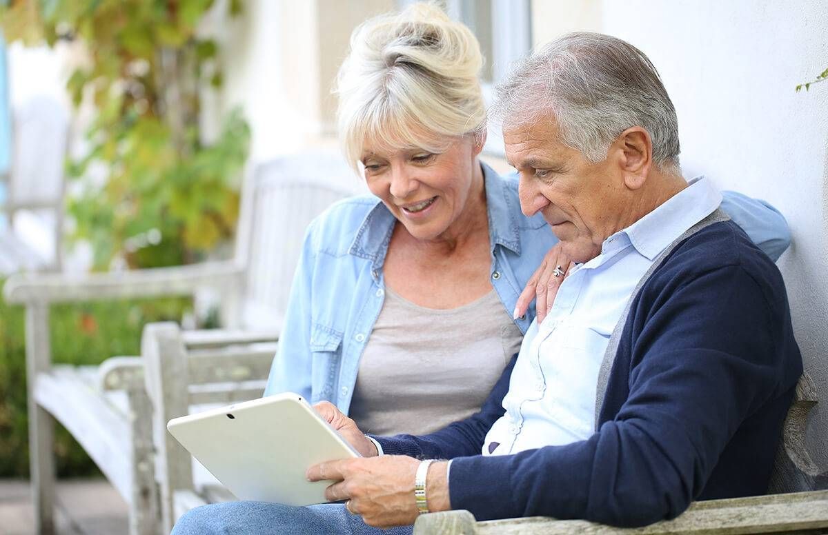Retired couple looking at their tablet device