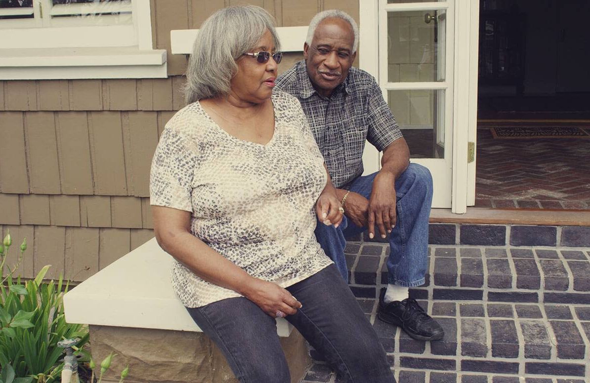 retired couple sitting on thier front stoop