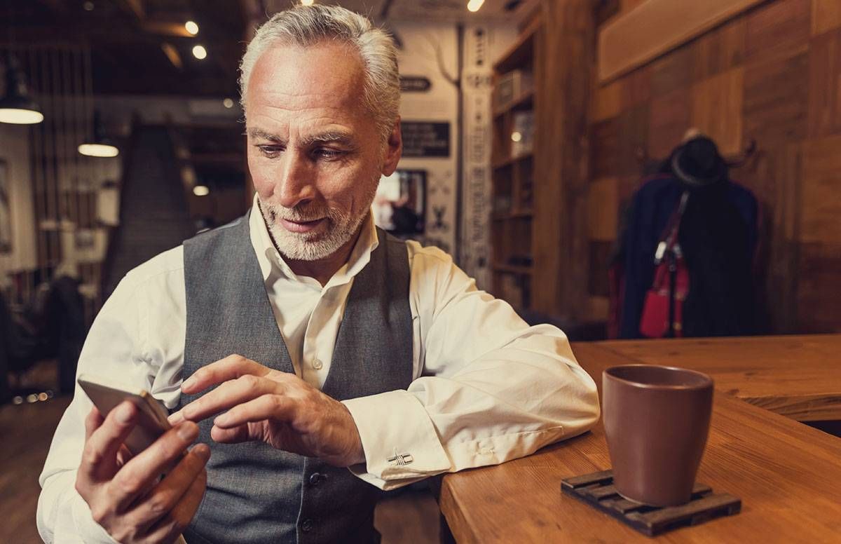 middle-aged man looking att content on his cell phone