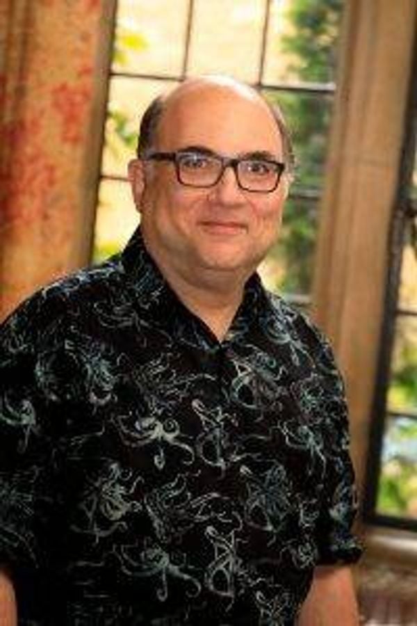 storyteller josh kornbluth in a printed shirt wearing glasses