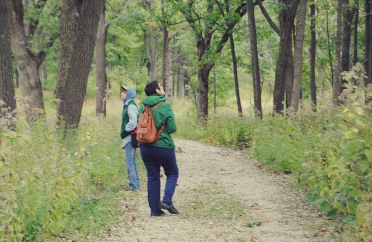 Two people on a hiking trail in the woods