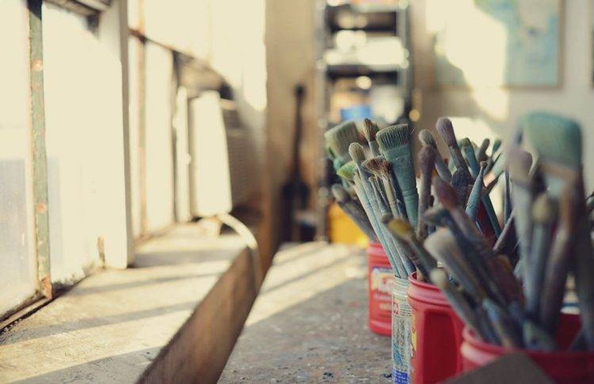 used paintbrushes sit next to a window in James Wrayge's Minneapolis studio