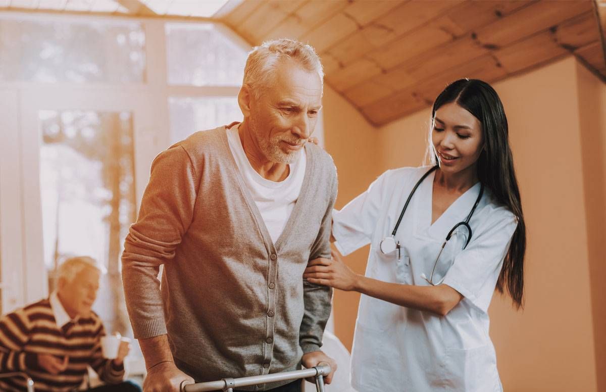 Physical therapist assists older patient