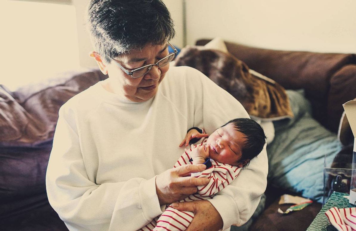 A grandmother holds her newborn grandchild