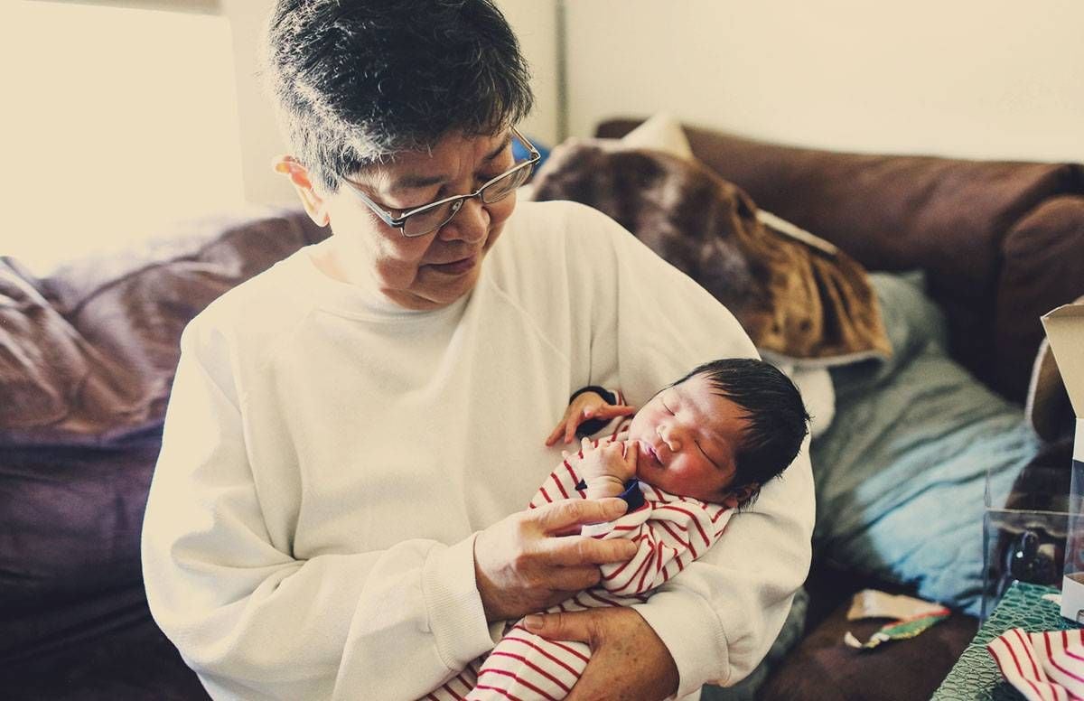 A grandmother holds her newborn grandchild