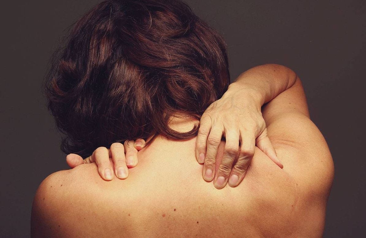 A woman with a naked back, touch her shoulders