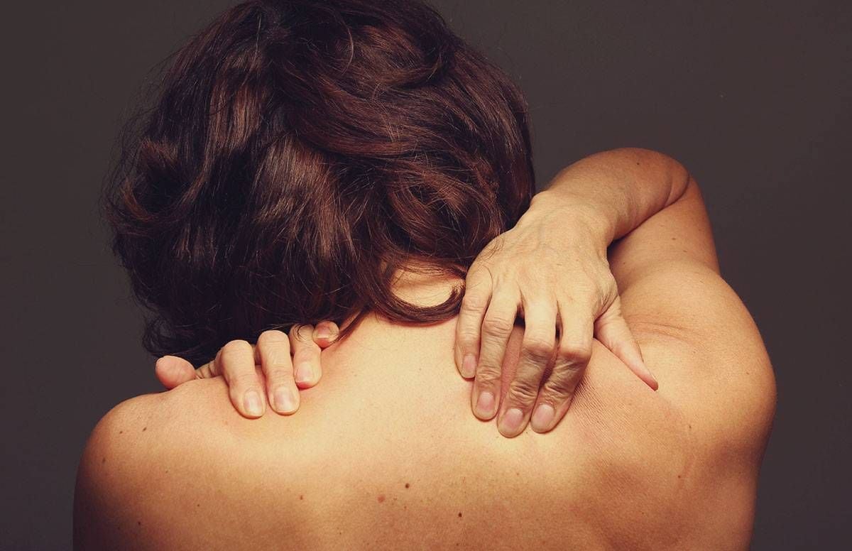 A woman with a naked back, touch her shoulders