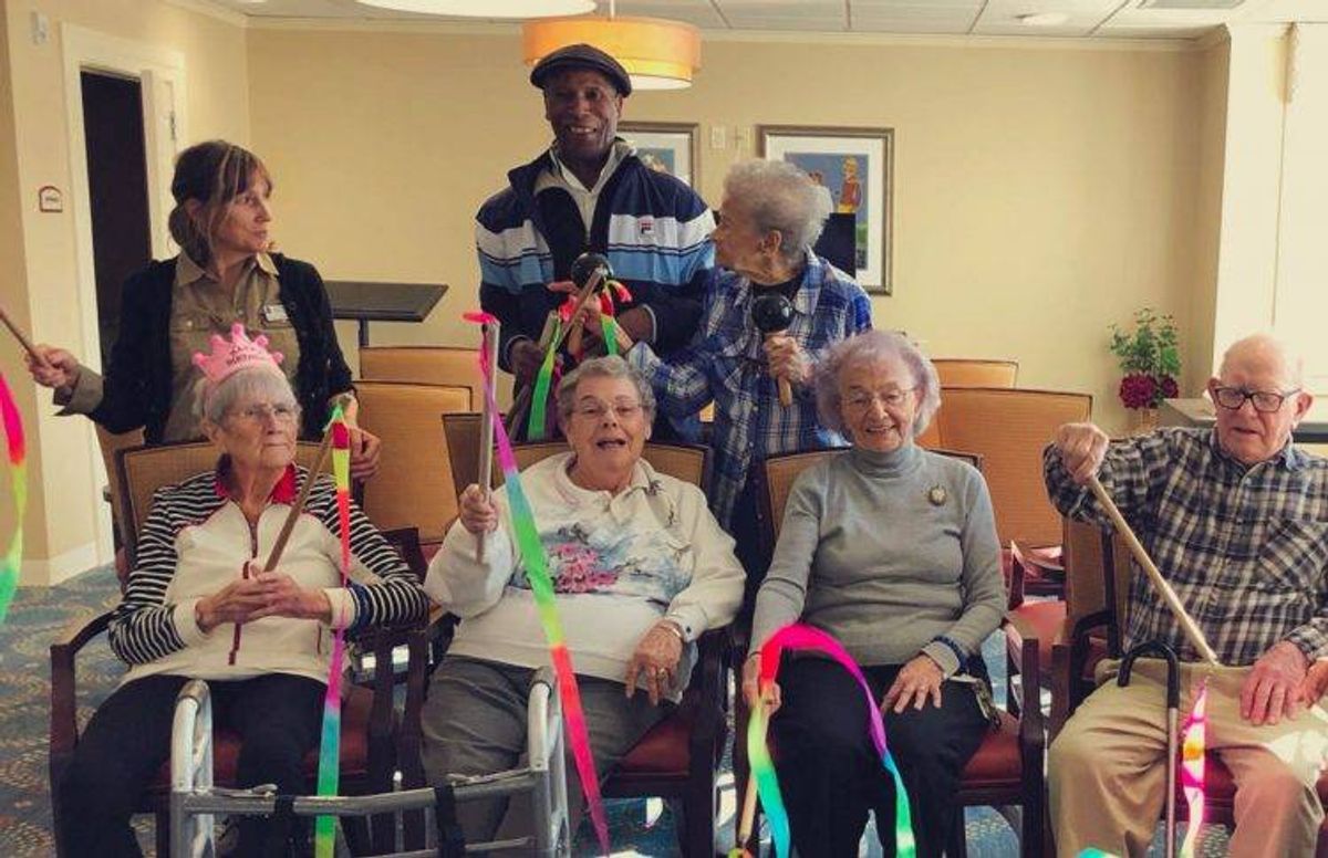 Art Carrington (standing in the middle) works with older adults at the Christopher Heights assisted living community in Northampton, Mass.