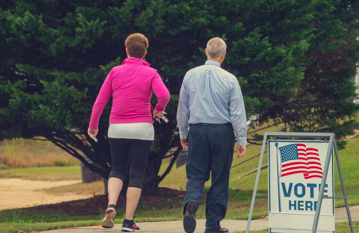 two middle-aged adults enter their polling place to vote