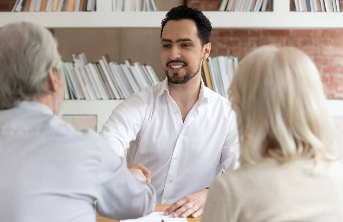 Lawyer shaking hands with older couple.