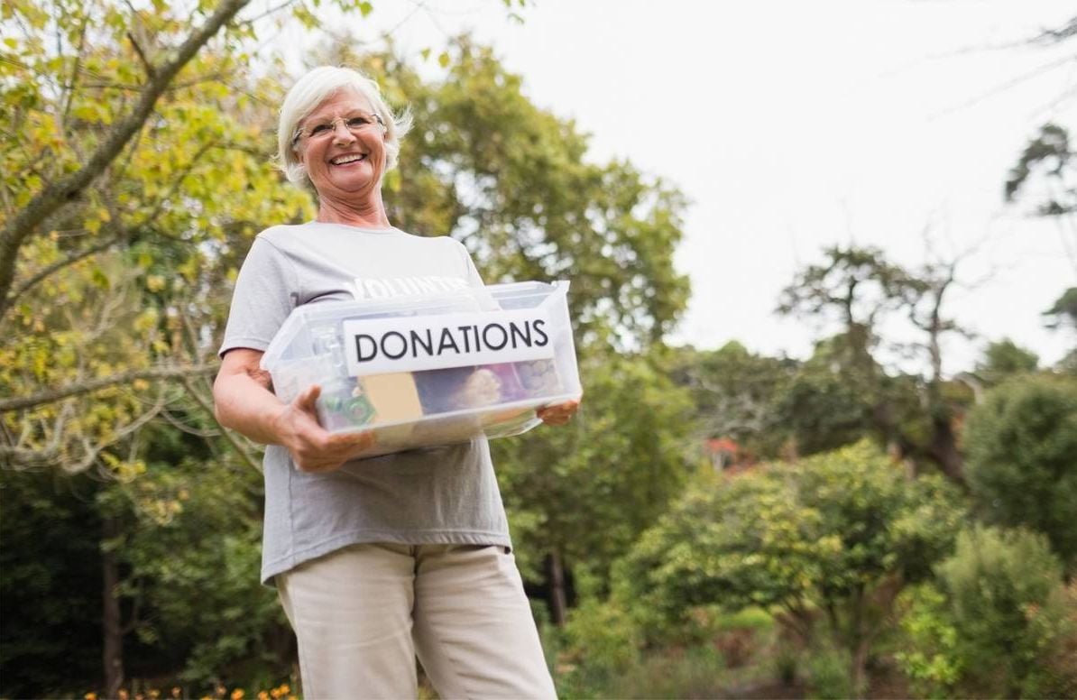 Volunteer holding a Donations box.
