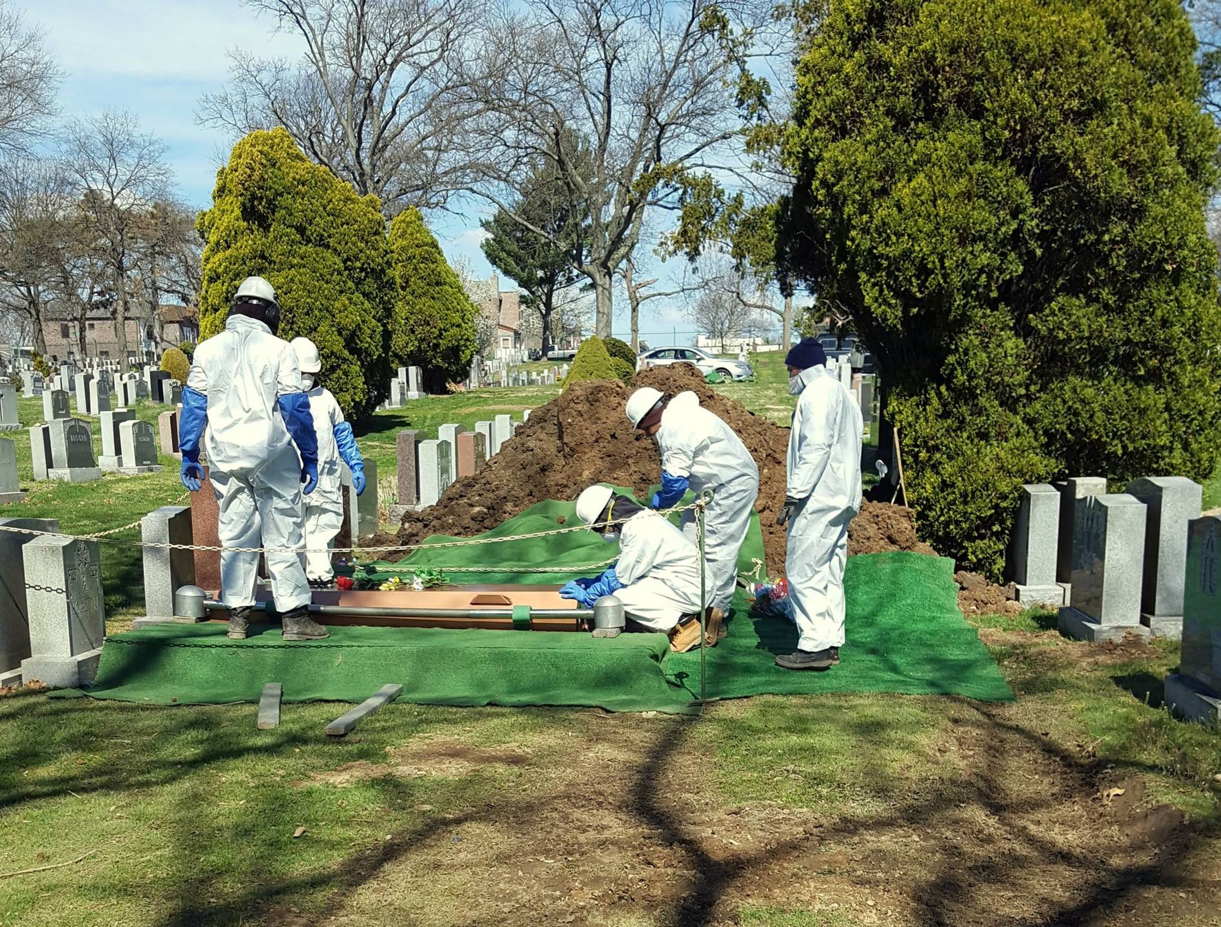 Gravediggers in protective clothing at a recent New York City-area funeral