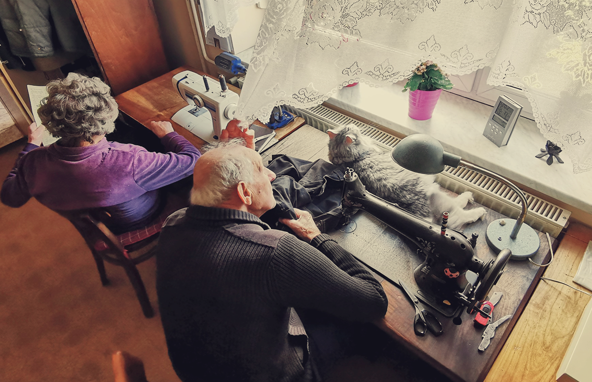 a married couple sitting by sewing machines looking out the window