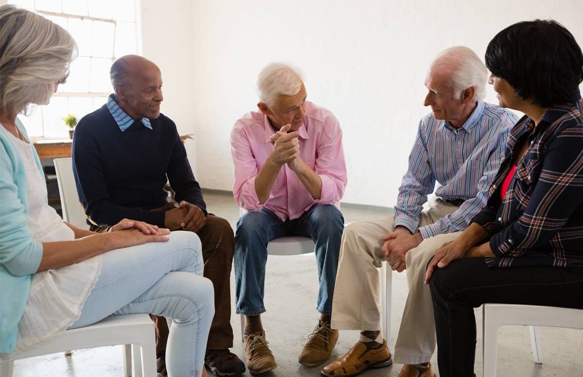 men sitting on chairs in semicircle