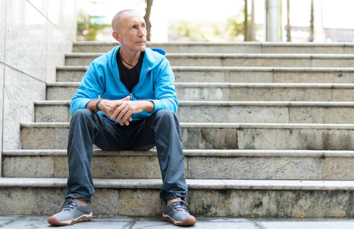 Man sitting on stairs, reflecting.