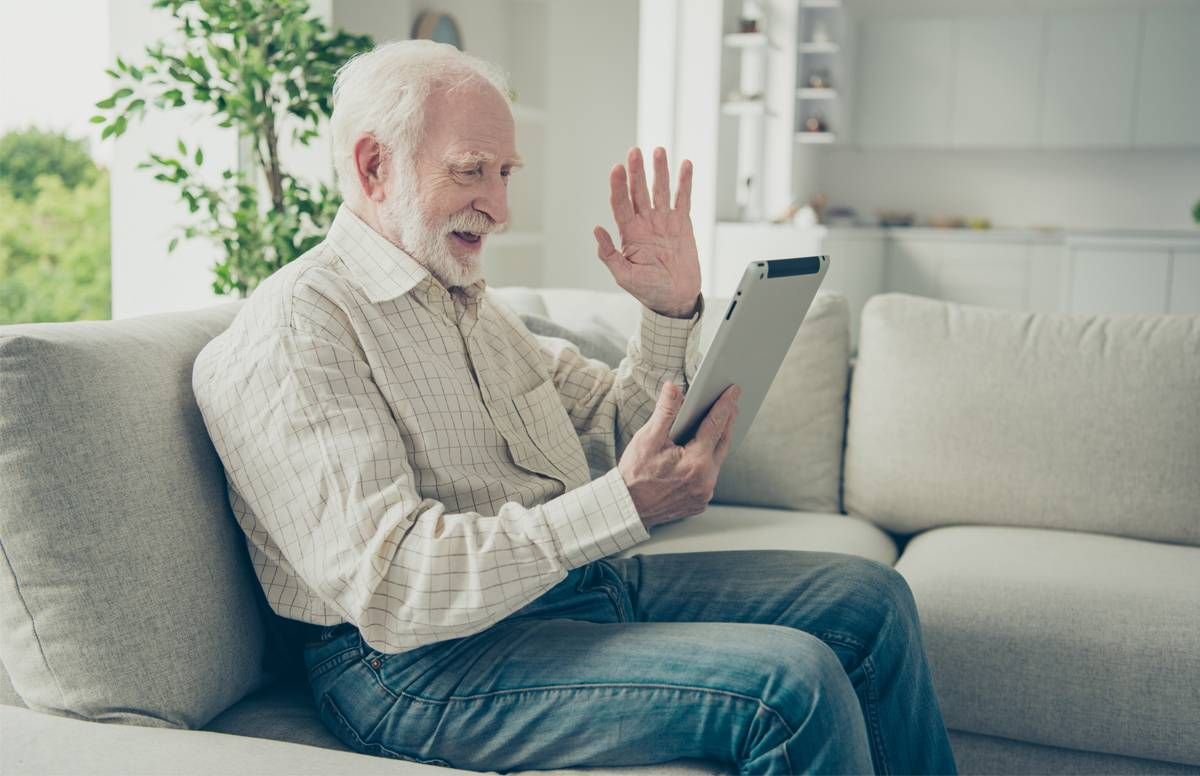 man waving at his tablet