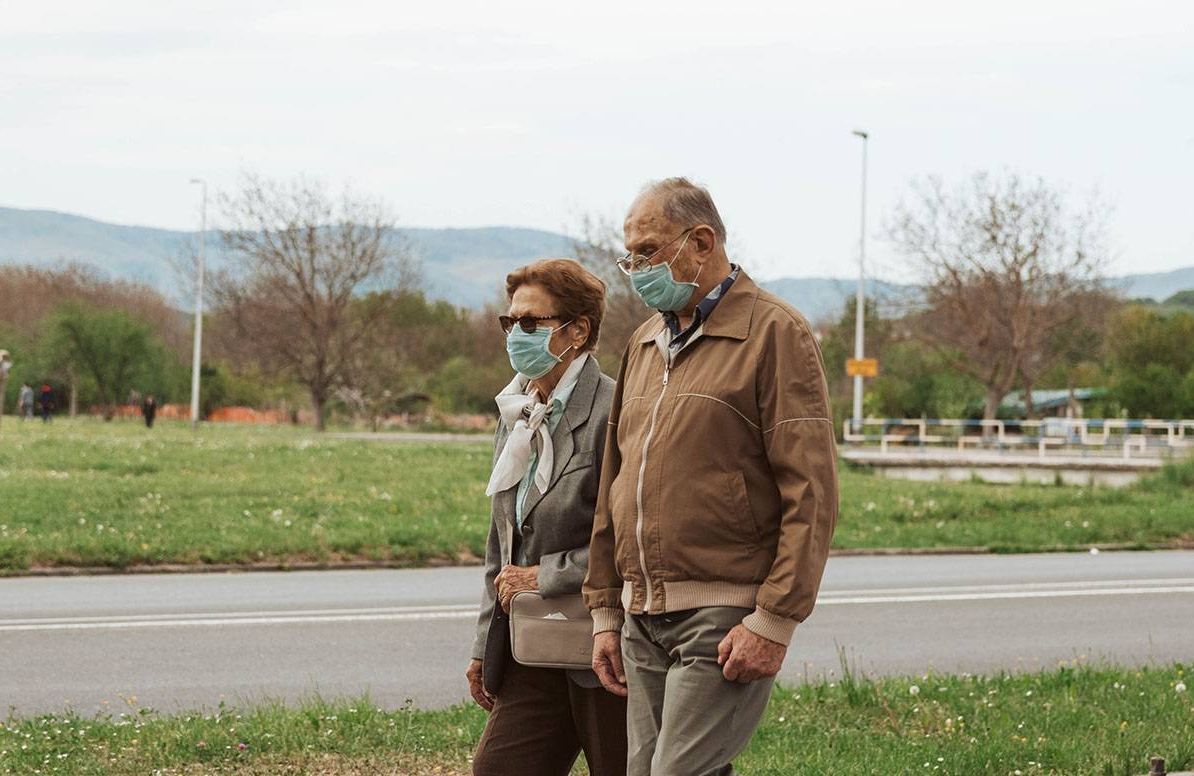 Older couple walking with masks