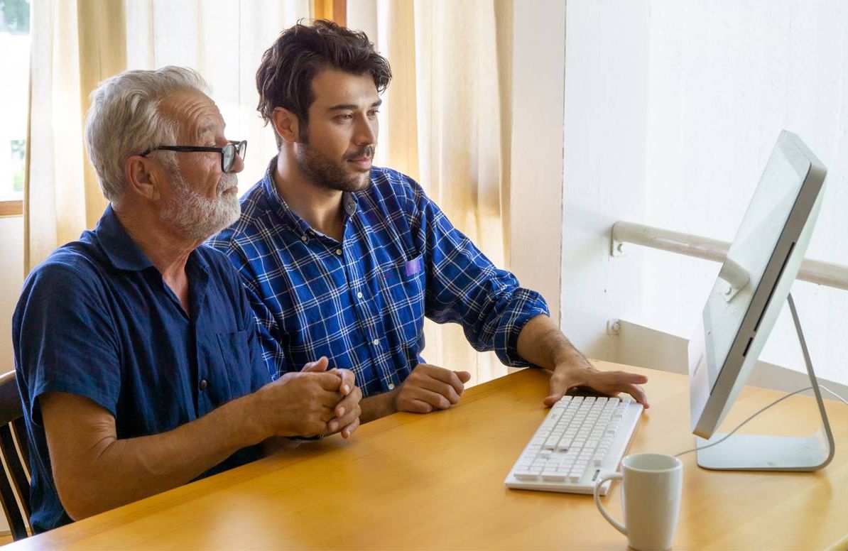 Middle-aged man helping his dad with finances