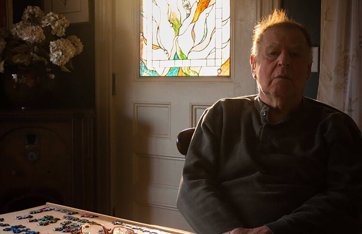 older man sitting at table at home