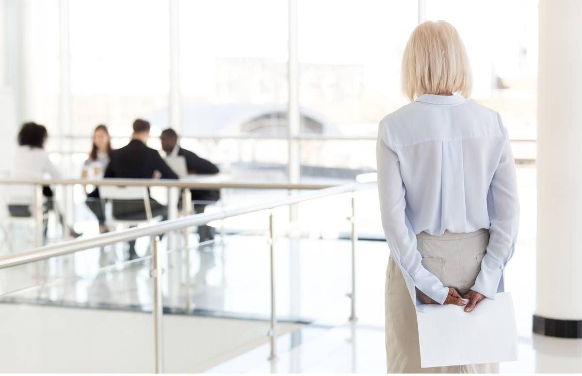 older employee appearing left out at work