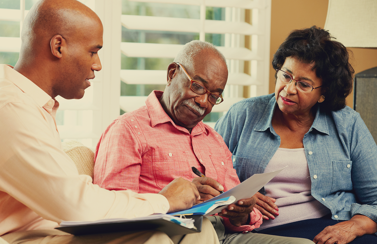 a middle aged couple in their living room meeting with a financial adviser