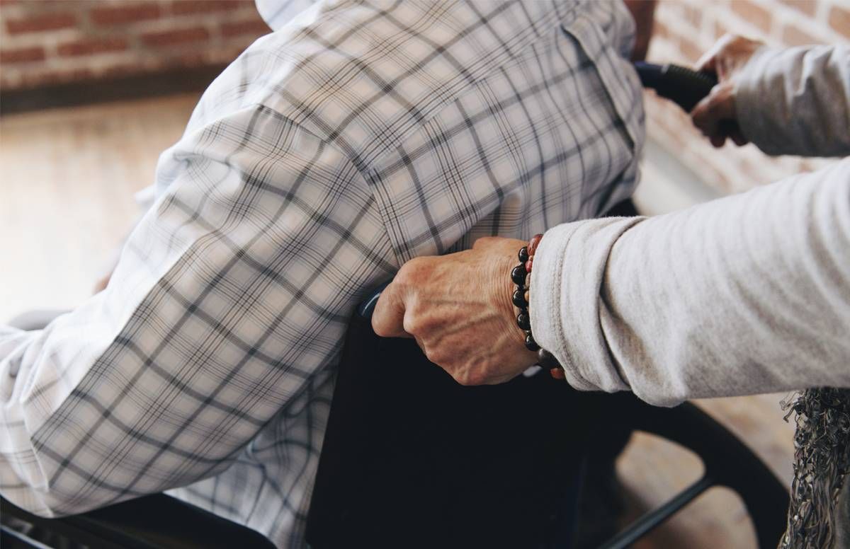 caregiver pushing her husband's wheelchair