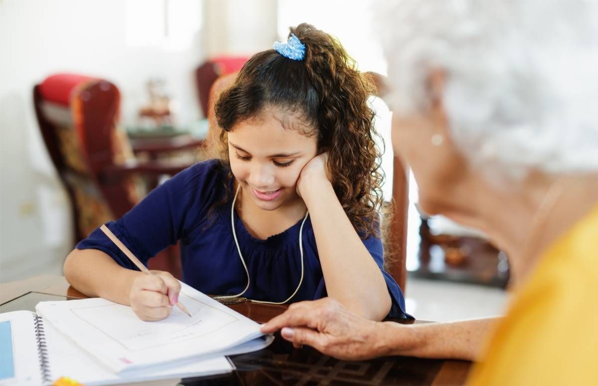 grandmother helping granddaughter with her studies