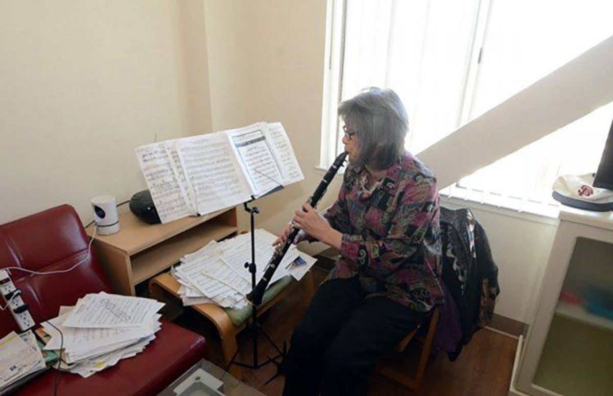 Jasmine Gee playing her clarinet in her apartment
