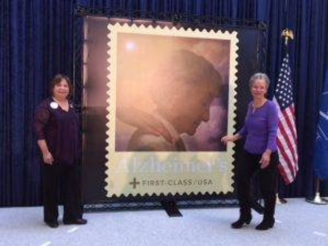 Siggins and Everman with their re-released Alzheimer's stamp