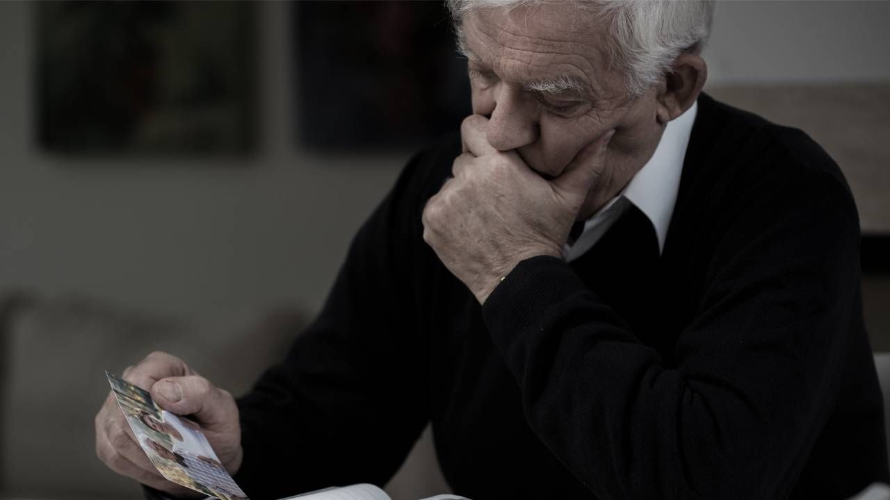 man looking at photos, Next Avenue, holiday depression