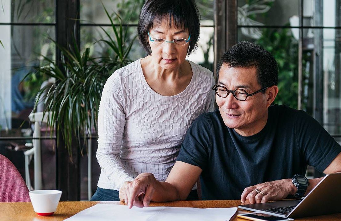 Couple looking over finances, retirement financial resolutions, Next Avenue