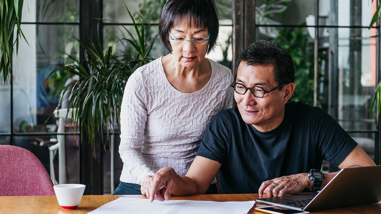 Couple looking over finances, retirement financial resolutions, Next Avenue