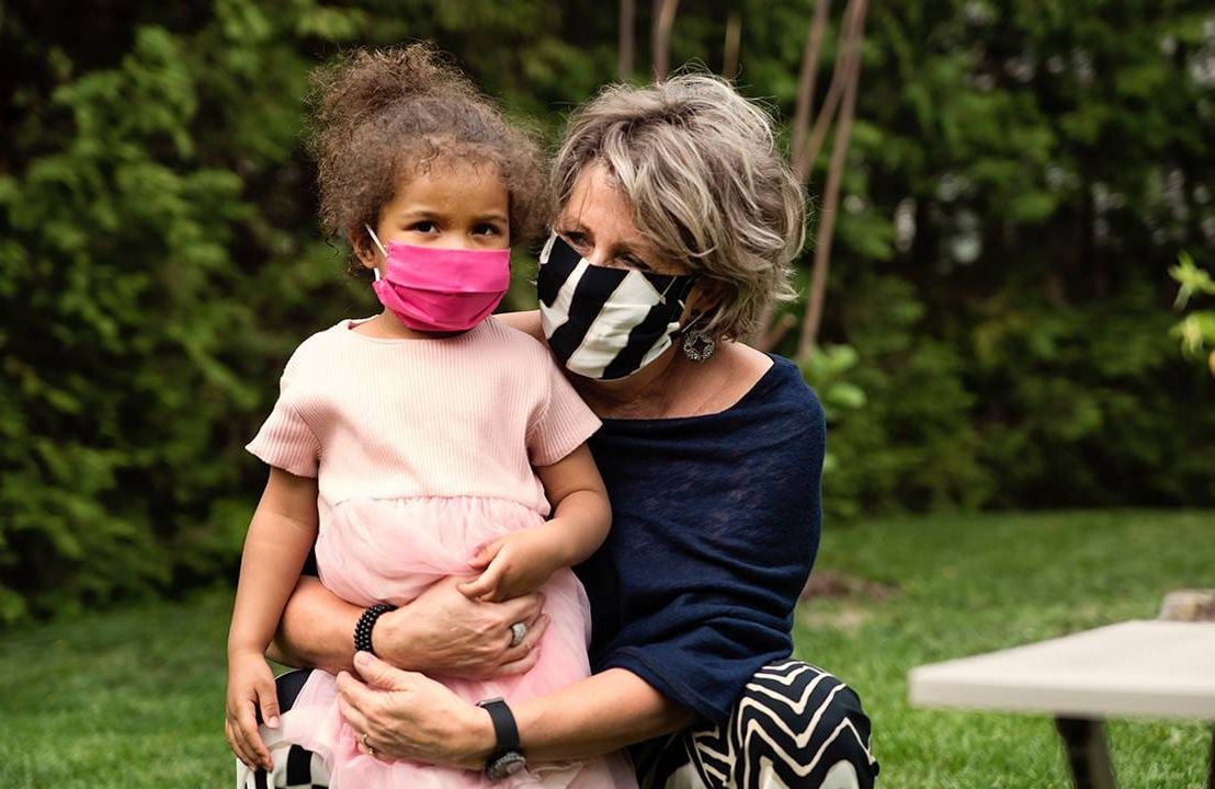 Grandmother and grandchild outside wearing face masks