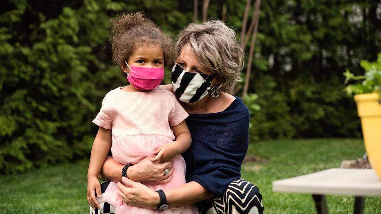 Grandmother and grandchild outside wearing face masks