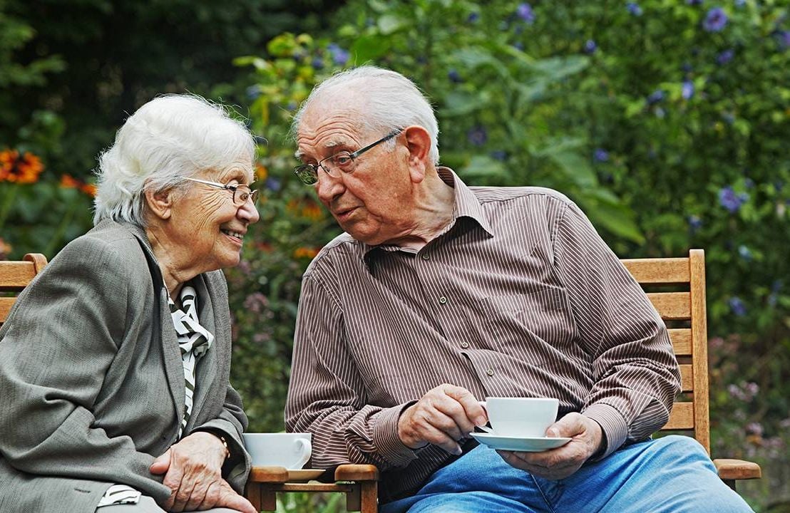 Older adults talking together in a garden, dignity and respect, Next Avenue, aging parents