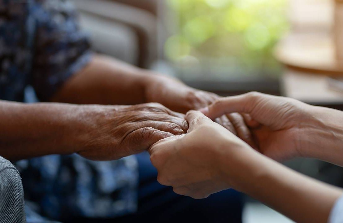 Chaplain holding the hands of an older adult in long term care, Next Avenue, chaplains, care