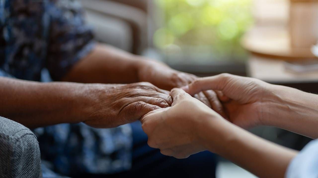 Chaplain holding the hands of an older adult in long term care, Next Avenue, chaplains, care