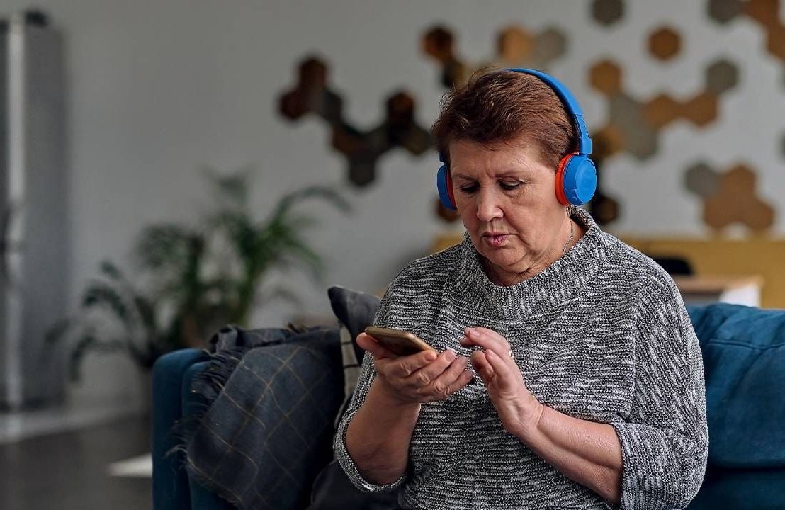 A woman listening to an audiobook with headphones, next avenue, audiobook, turn up audiobooks