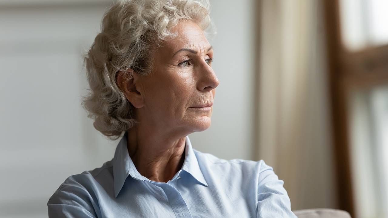 Woman in collared shirt looks out the window, workplace bias training, agism, Next Avenue, age bias