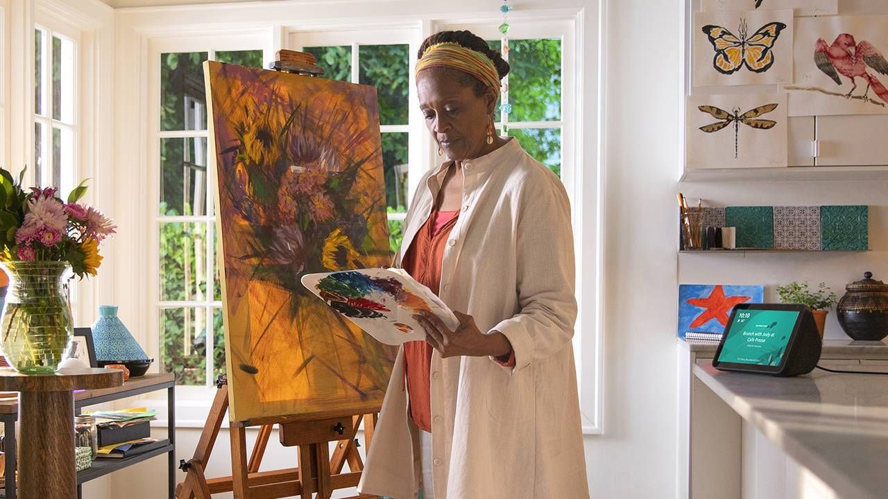 Woman painting in her kitchen with Alexa on countertop, caregiver, Alexa, Next Avenue