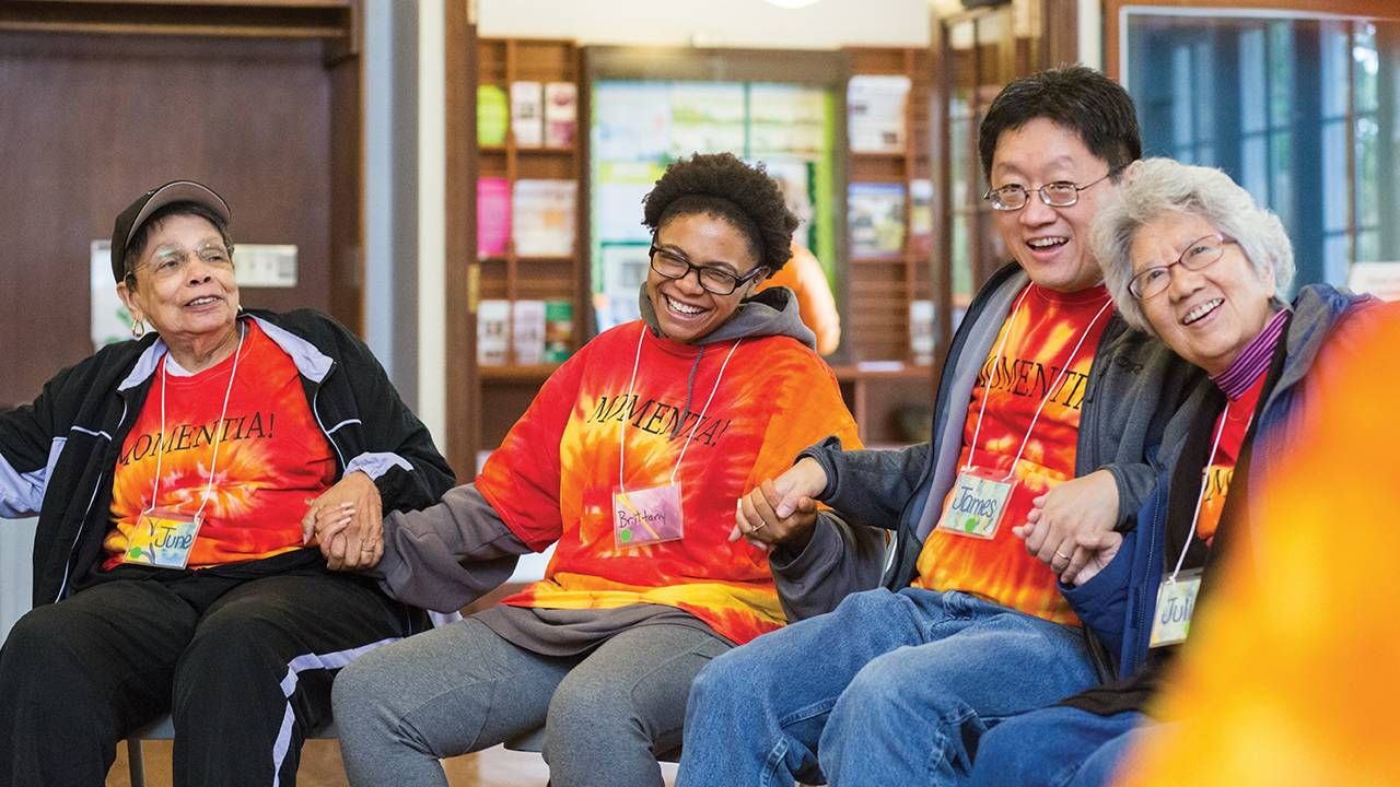 Group of four people holding hands and laughing, dementia, Alzheimer's, Next Avenue