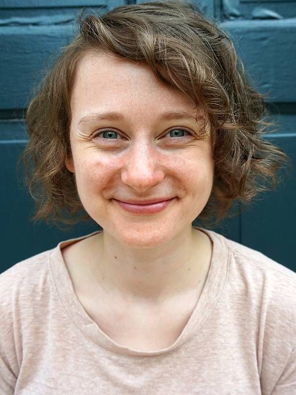 smiling young woman in front of green door, conversation, social isolation Next Avenue