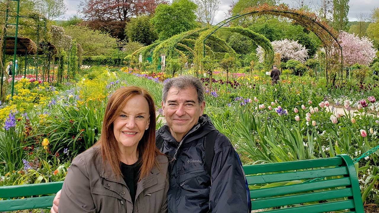 Couple sitting on a bench outside in a spring garden, bucket list, travel, Next Avenue