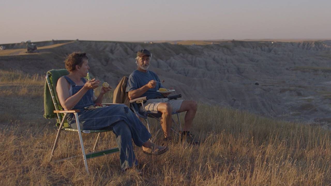 Film still of actors eating outside in the Badlands, Nomadland, Next Avenue