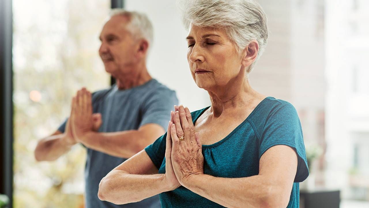Older couple doing yoga at home, aging, Next Avenue