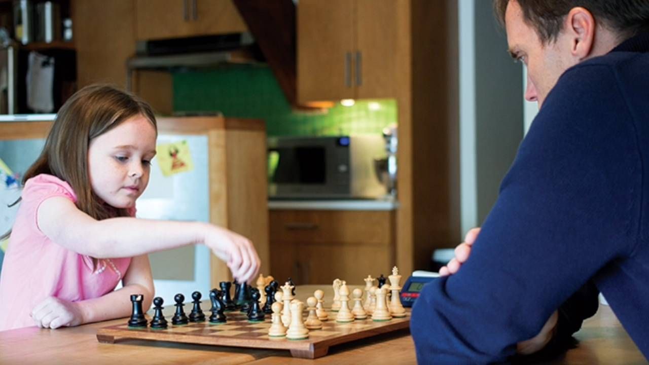 Father and daughter playing chess at home, beginners, lifelong learning, Next Avenue