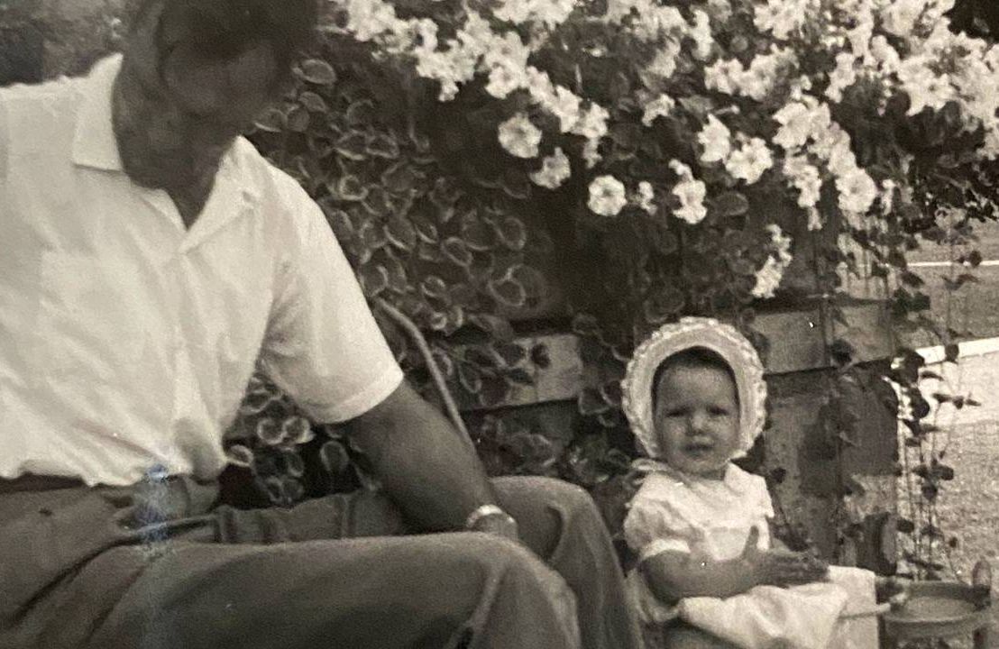 Old photo of a young father and a baby girl wearing a bonnet outside, dad, Next Avenue
